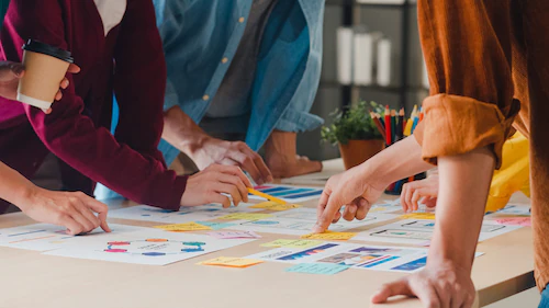 A team arranging coloured feature cards on a table while scoping an MVP
