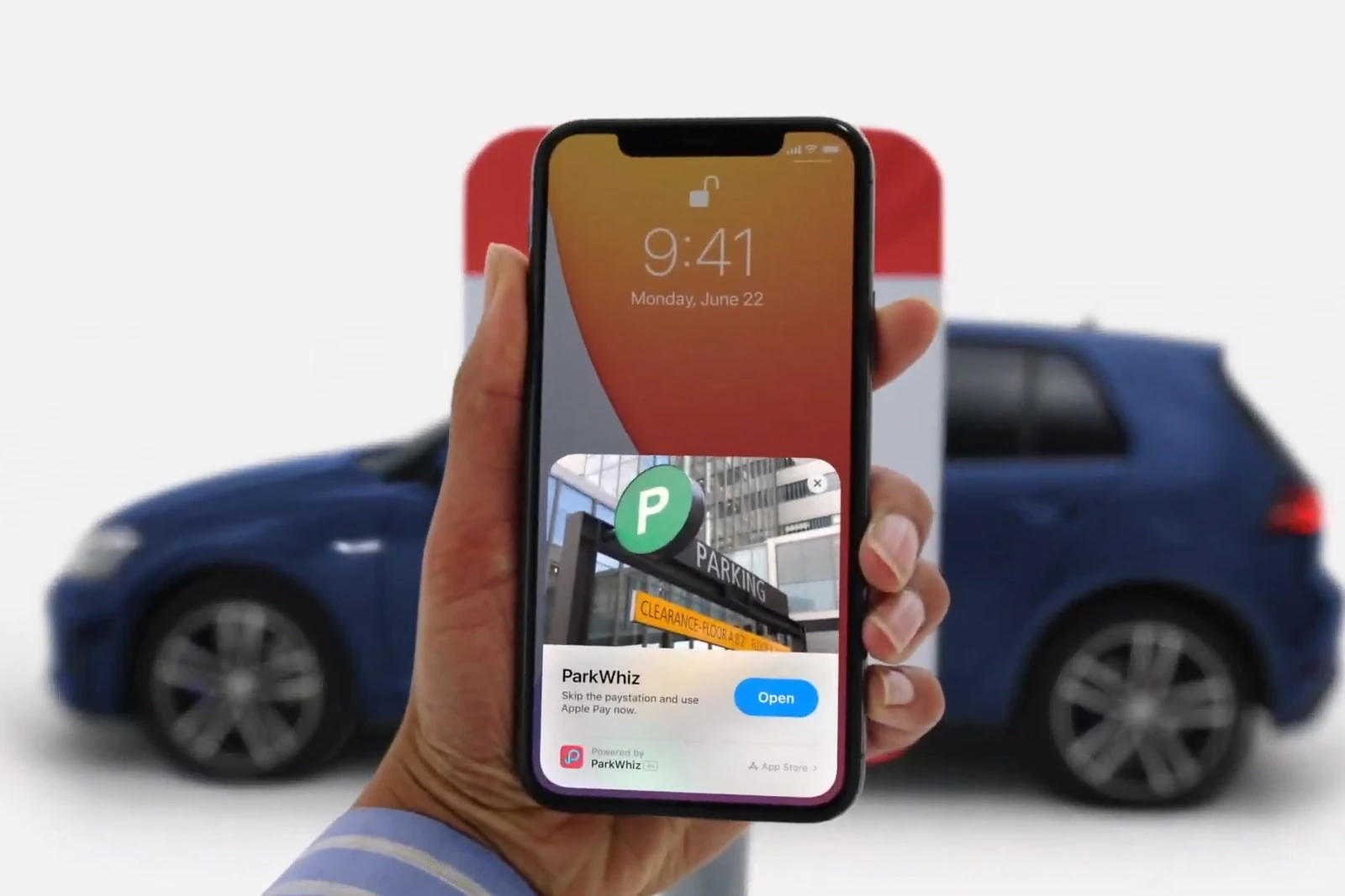 An iPhone showing an App Clip card above a photo of a car