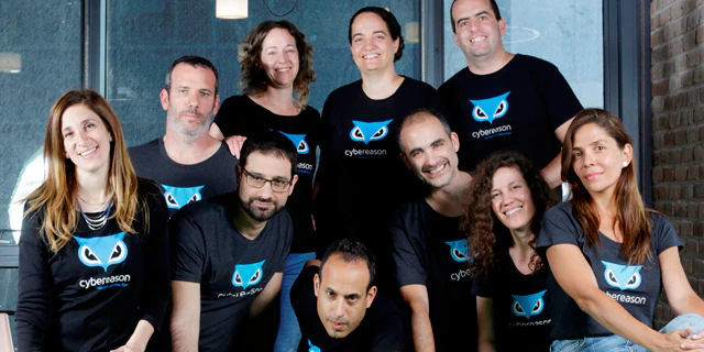 A startup team photographed together in matching company shirts