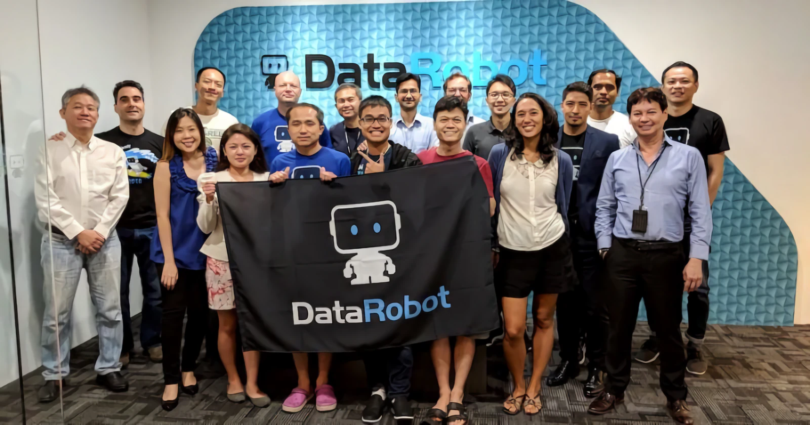 The DataRobot team holding a company banner at an event