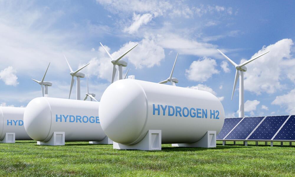 Hydrogen storage tanks beside wind turbines and solar panels