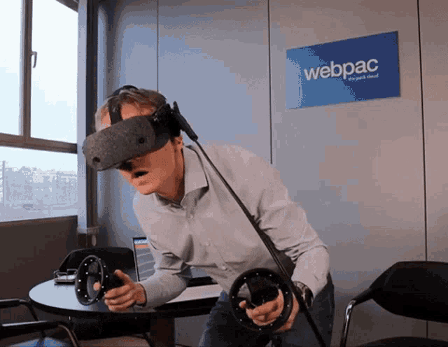 A person working at a desk while wearing a VR headset